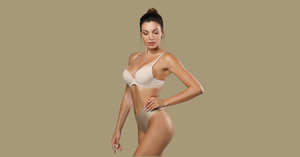 An attractive woman in a nude-colored swimsuit highlighting her flawless figure.